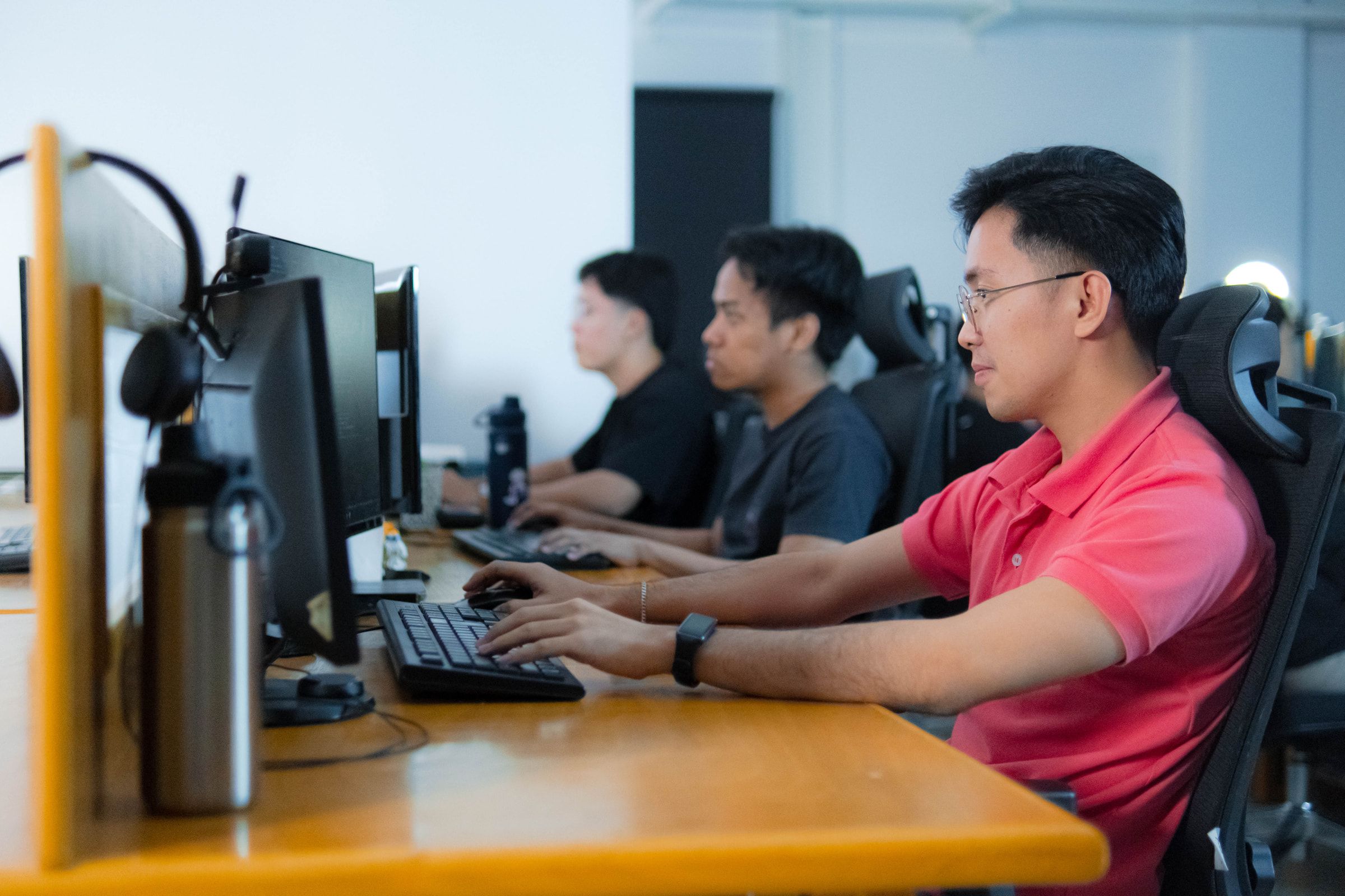 Yoonet teammates working at their monitors in the Balanga office