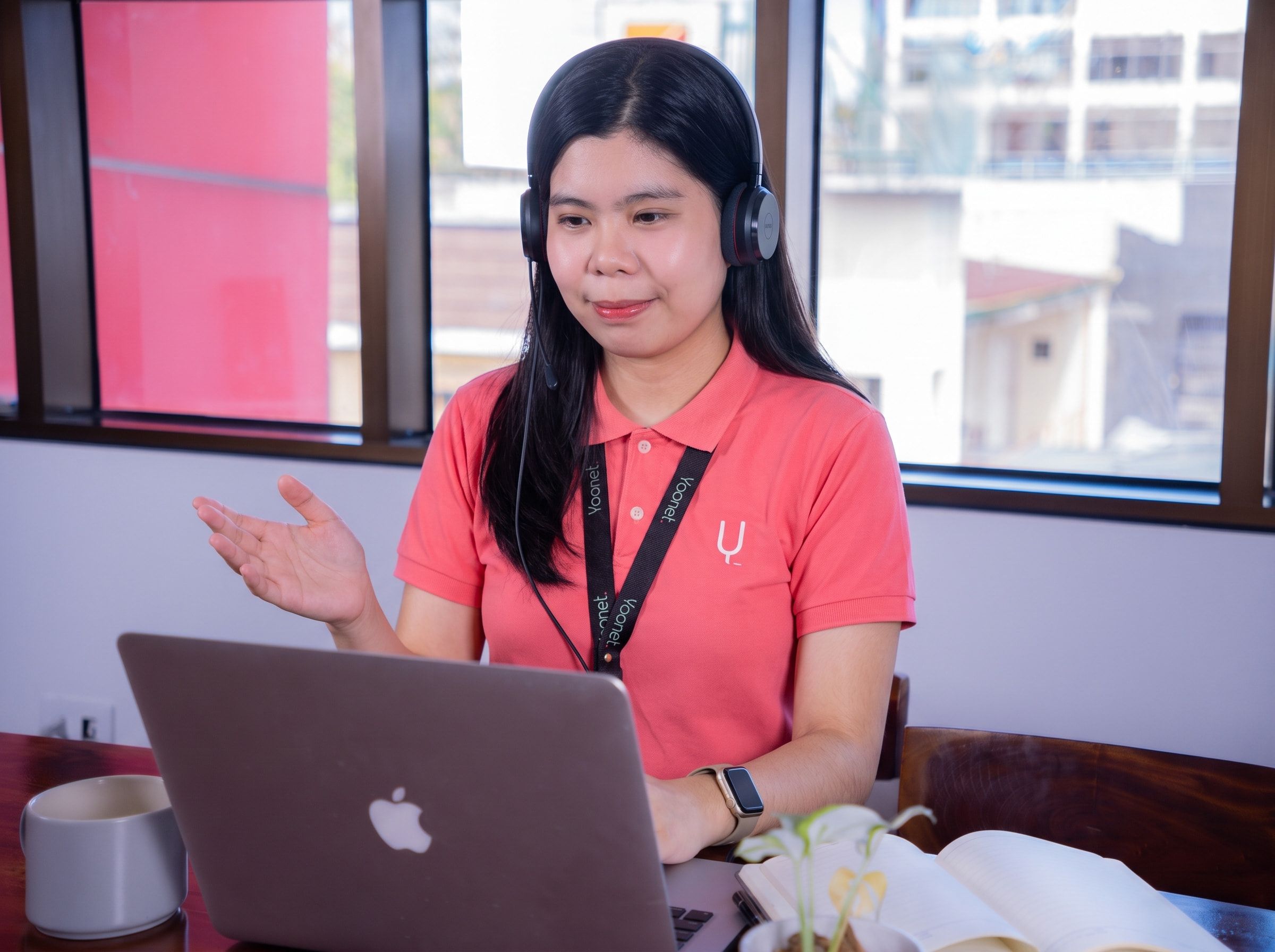 Yoonet teammate on a video call with a client, headset on