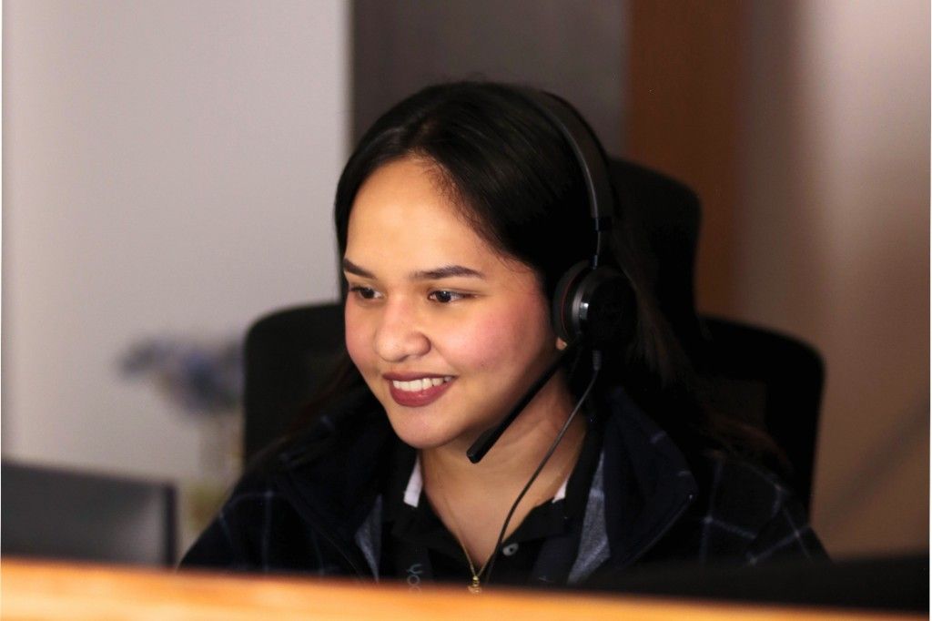 Yoonet practice admin teammate wearing a headset at her desk in the Balanga office