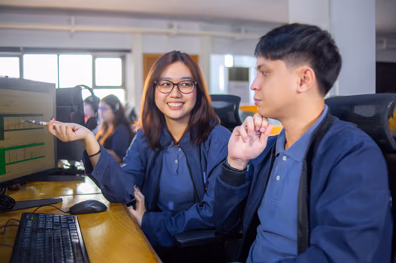 Two Yoonet colleagues discussing work on a computer screen