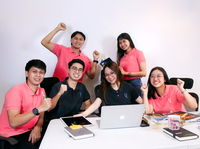 Yoonet team celebrating together around a laptop