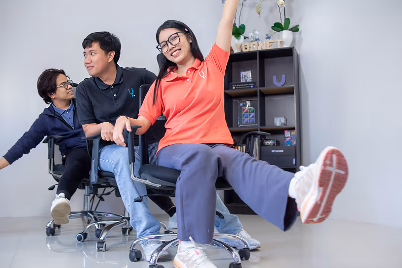Three Yoonet team members smiling and having fun at the office